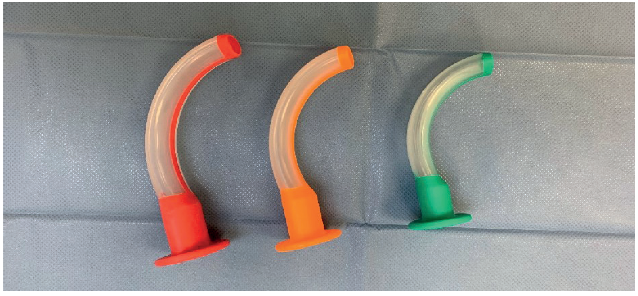 Three oropharyngeal airways (Guedel) in different sizes - red (large), orange (medium), green (small)